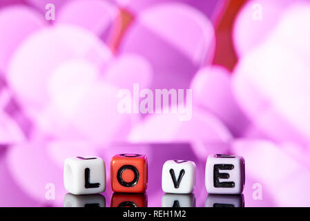 Word love  from cubes with reflection on bright blurred background. Stock Photo