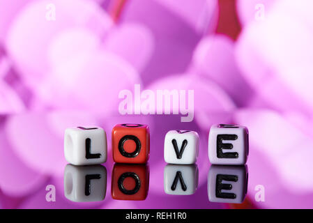 Word love  from cubes with reflection on bright blurred background. Stock Photo