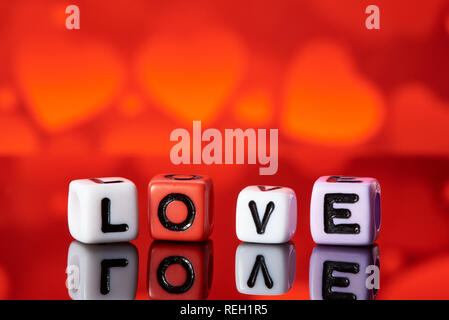 Word love  from cubes with reflection on bright blurred background. Stock Photo