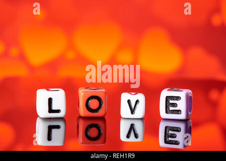 Word love  from cubes with reflection on bright blurred background. Stock Photo
