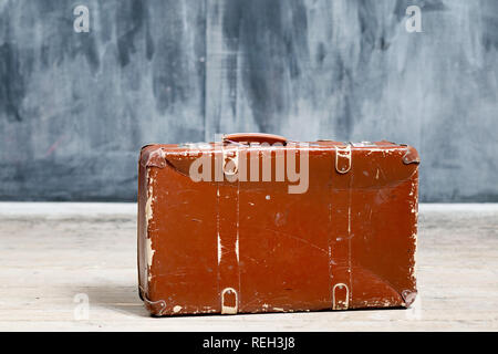 Old plywood shabby suitcase near the dark wall in chalk Stock Photo