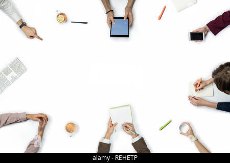 Large group of people at business meeting, top view. Flat lay with copy space of diverse people hands around a table. Stock Photo