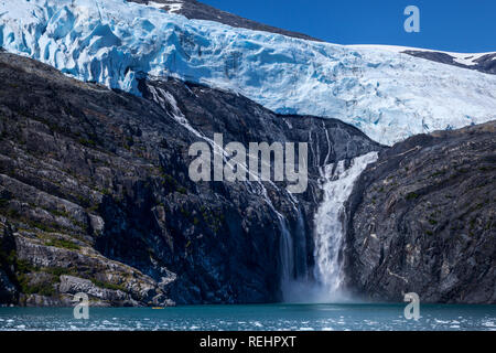 A kayaker paddles among ice burgs in Blackstone Bay to view the melt-water falls of Northland Glacier Stock Photo