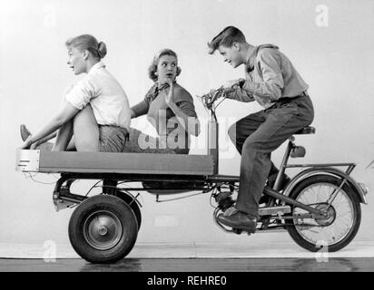 Teenagers of the 1950s. A teenage boy with two girls on the Monark transportation moped. Sweden 1950s. Stock Photo