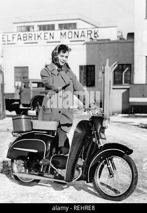 Woman of the 1950s. A young woman with a new Monark moped in front of the factory 1957. Stock Photo