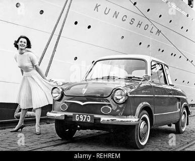 Driving in the 1950s. A young woman is standing beside a car NSU. The cruise ship Kungsholm is anchored at the docks and makes a nice background. She wears a typical 1950s skirt with matching short-armed jumper and a scarf. 1950s Stock Photo