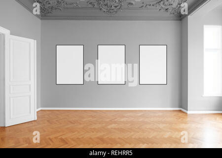 empty room with three blank picture frames hanging on wall in apartment Stock Photo