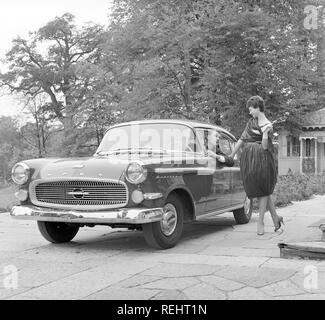 Driving in the 1950s. A young woman is standing beside a car Opel Kapitän, talking to a man behind the wheel. She is fashionable dressed in a typical 1950s dress. Photo Kristoffersson Ref CB93-3 Stock Photo