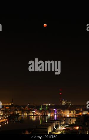 Total lunar eclipse over a city Stock Photo
