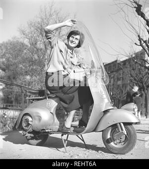 Driving in Italy in the 1950s. A young woman on a Vespa scooter in Milan Italy 1950. Photo Kristoffersson Ref AY26-12 Stock Photo