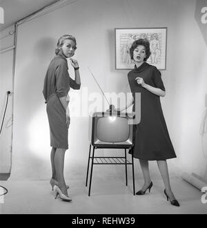 Television in the 1950s. Two young women are standing dressed in a typical 50s dress beside a televison set with an table antenna on top of it. In 1952 1.4 million households in Britain had a television.  Photo Kristoffersson ref BZ26. Sweden 1952 Stock Photo