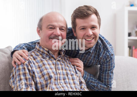 Adult father and son relaxing at home Stock Photo