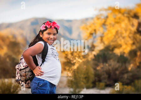 Elementary school female student wearing a backpack and smiling during a school field trip in southern california. Stock Photo