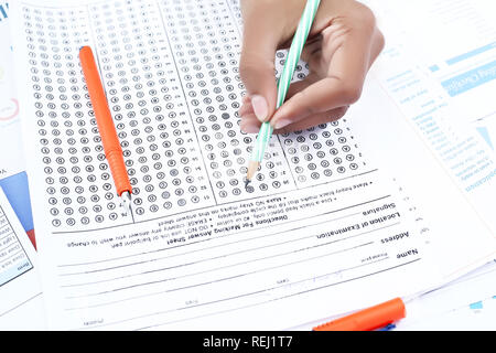 Man is filling omr sheet with pencil. Picture of pen on the omr sheet. Stock Photo