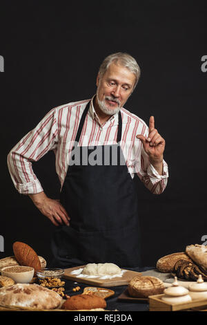 Male senior chef isolated on black background Stock Photo