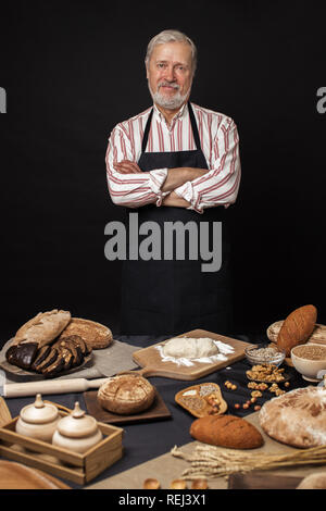 Male senior chef isolated on black background Stock Photo