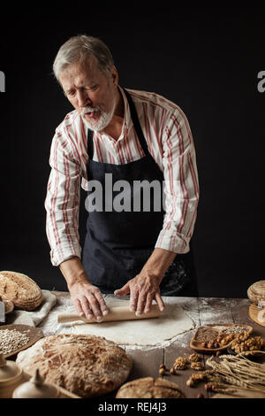 Experienced Baker Man preparing dough for homemade bread in the kitchen.
