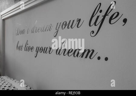 Inspirational motivating quotes on wall, text don't dream your life but life your dream Stock Photo