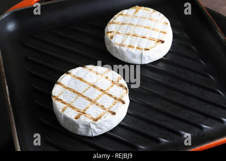 Tasty chequered camembert cheese frying on cast iron grill pan. Fresh grillde brie cheese Stock Photo