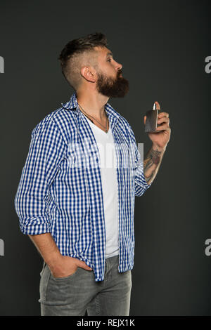 Man bearded handsome hold bottle perfume. Fragrance for brutal hipster. Fashion and beauty treatment. Masculine fragrance for brutal guy. Masculinity concept. Perfume male fragrance. Smell fragrance. Stock Photo