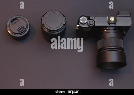 mirrorless interchangeable-lens system photo camera with two lenses on dark black background. low key image from above Stock Photo