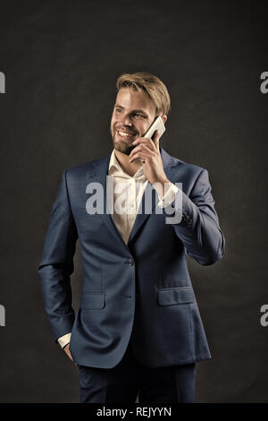 Businessman or ceo fashion. Manager with beard on happy face hold phone. Man in formal outfit with mobile phone. digital marketing and new technology. Business communication and modern life. Stock Photo