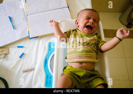 A child being weighed at a primary health facility in Pakistan. Stock Photo
