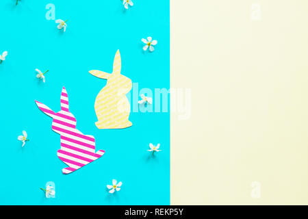 Easter bunny paper and spring flowers. Minimal easter concept. Top view flat lay background. Copy space. Stock Photo