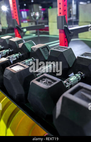 Dumbbells, pancakes and weights lying on the shelves. Gym. Equipment for gym Stock Photo