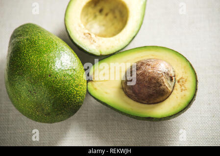 Avocado fruit cut in half on the light background. The concept organic eco products for food and cosmetic procedures Stock Photo