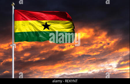 flag of Ghana on flagpole fluttering in the wind against a colorful sunset sky. Stock Photo