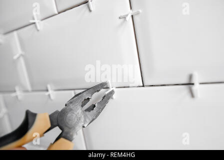 Ceramic tile lying. Installing new subway or metro tile in bathroom, shower or kitchen back splash during home renovation. Placing or taking out tile Stock Photo