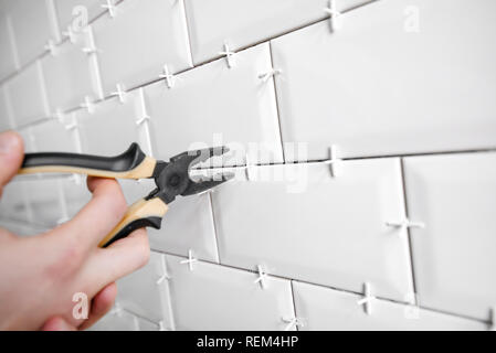 Ceramic tile lying. Installing new subway or metro tile in bathroom, shower or kitchen back splash during home renovation. Placing or taking out tile Stock Photo