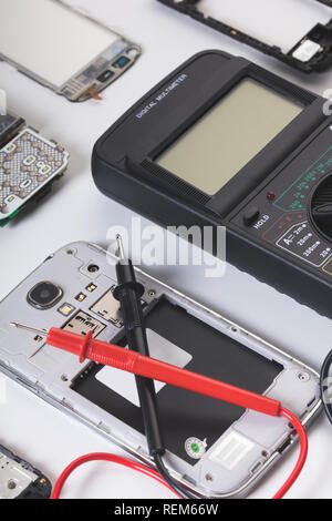 disassembled mobile phone and tools on white background Stock Photo