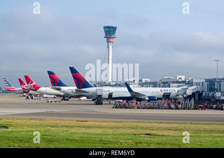LONDON, UK - JUNE 12, 2018: Planes belonging to Delta, Virgin Atlantic and American Airlines parked at Terminal 3 of London's Heathrow Airport on a su Stock Photo