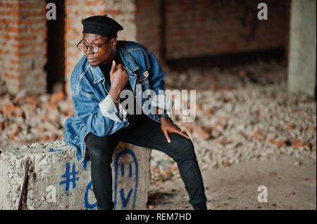 African american man in jeans jacket, beret and eyeglasses at abandoned brick factory. Stock Photo