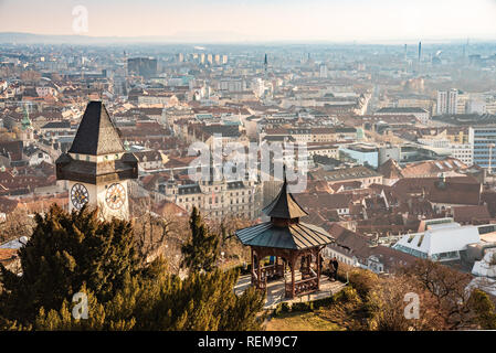 Graz, Styria / Austria - 20.01.2019: View at Graz City from Schlossberg hill, City rooftops, Mur river and city center, clock tower Sun on the winter  Stock Photo