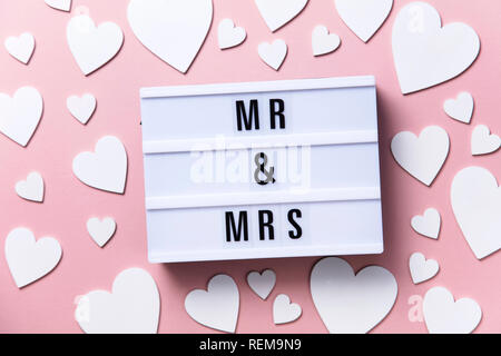 Mr and Mrs lightbox message with white hearts on a pink background Stock Photo