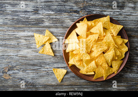 Nachos corn chips in a plate on a wooden table. Mexican food concept. Top view. Stock Photo