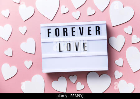 Forever Love lightbox message with white hearts on a pink background Stock Photo