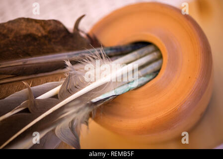 Feather pen in clay inkwell. Medieval, vintage, retro background.  writing with old quill pen on the old paper. Historical atmosphere. Writing calligr Stock Photo