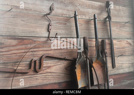 Blacksmith tools hanging on wall in workshop Stock Photo
