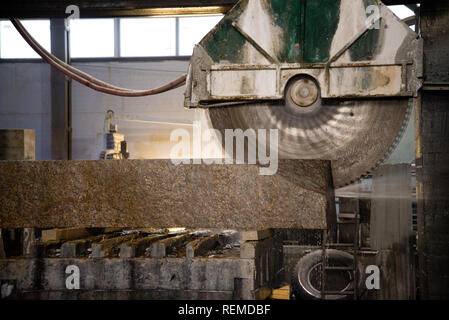 Granite processing in manufacturing. Cutting granite slab with a circular saw. Stock Photo