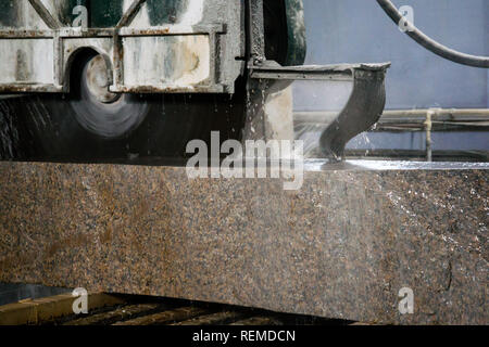 Granite processing in manufacturing. Cutting granite slab with a circular saw. Stock Photo