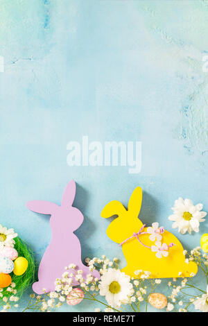 Happy Easter Card. Congratulatory easter background. Easter eggs, Easter eggs cute bunny and flowers. Top view flat lay background. Copy space. Stock Photo
