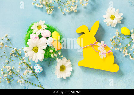 Easter background Card.  Easter eggs cute bunny with Easter eggs and spring flowers. Top view flat lay background. Stock Photo