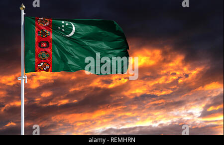 flag of Turkmenistan on flagpole fluttering in the wind against a colorful sunset sky. Stock Photo