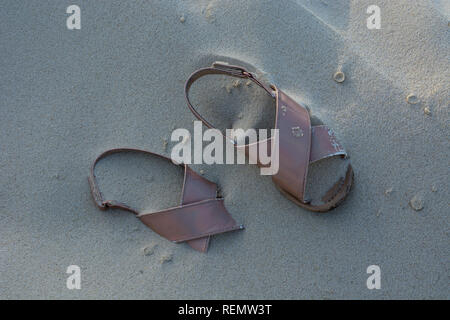 Abandoned pink sandals on a beach Stock Photo