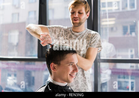 Handsome man at the hairdresser getting a new haircut Stock Photo