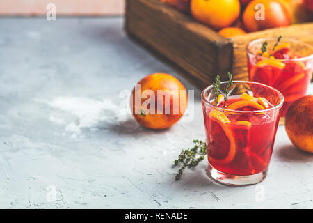 Campari or alcohol cocktail with Sliced Sicilian Blood oranges and fresh red orange juice on light gray concrete background, copy spice, shallow depth Stock Photo